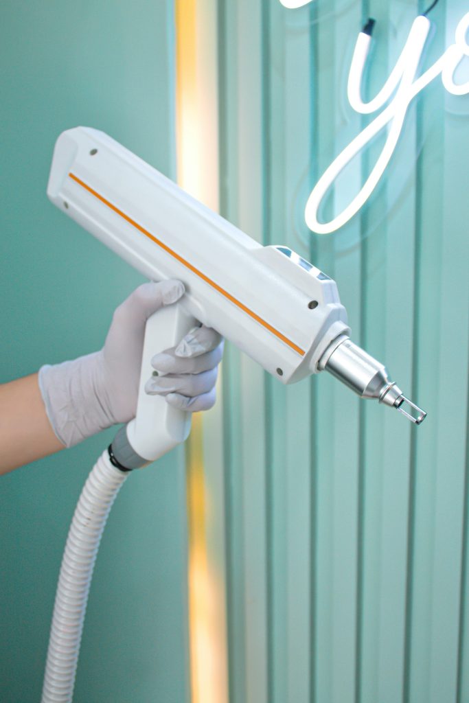 A hand in a glove holds a medical device against a green background, showcasing medical technology.