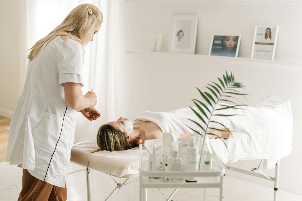A serene spa setting featuring a facial treatment with a professional beautician, highlighting relaxation and skincare.