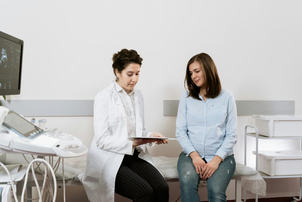 A pregnant woman consulting with a gynecologist in a medical facility.