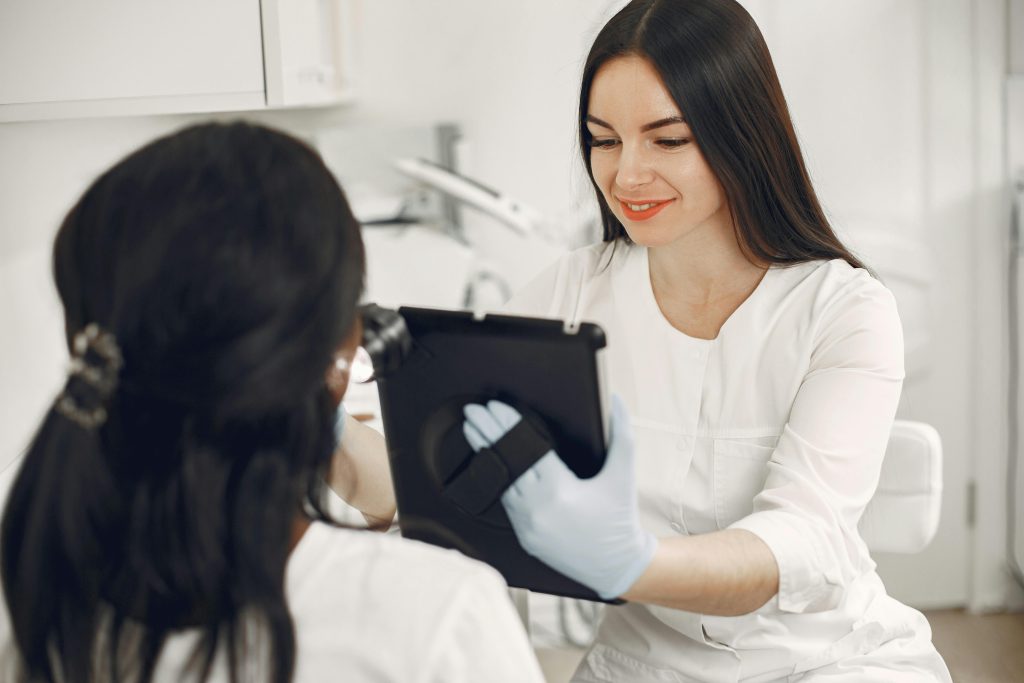 A beautician consults a client using a tablet in a modern beauty spa setting.